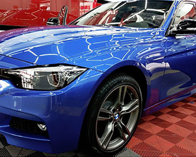 Blue sedan with glossy paint protection film finish